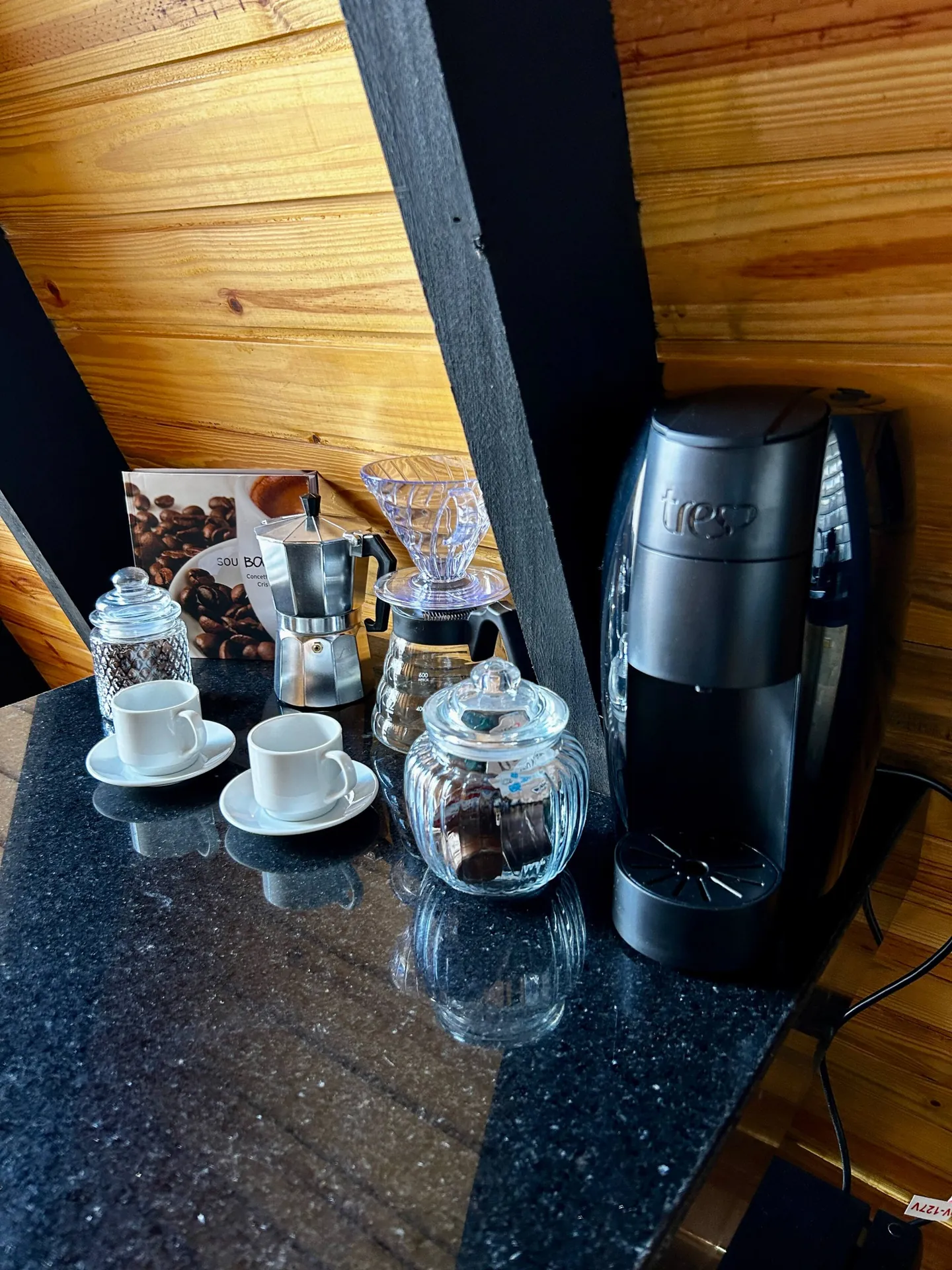 Cantinho do café com cafeteira, xícaras e potes de grãos